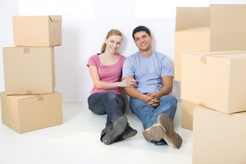 Removal team carrying furniture from a Catford property