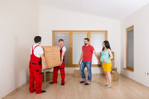Movers preparing furniture for transport in a Catford street
